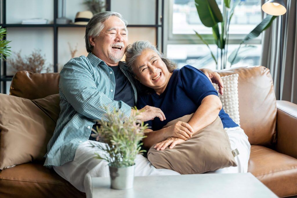 smiling asain couple on couch