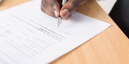 man signing a paper contract